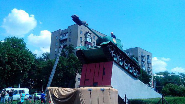 Мужчина прикрепил к дулу танка ремень. закрепленный на шее. Фото donnews.ru