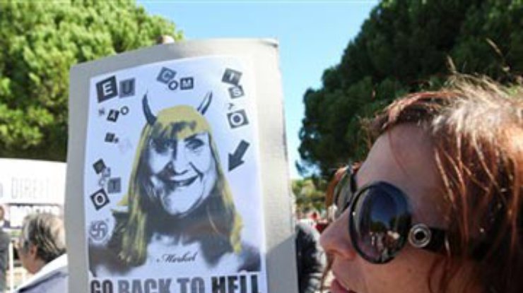 Меркель в Португалии встречают нецензурщиной и трауром
