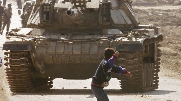 Палестинец бросает камень в израильский танк. Сектор Газа. Фото: Thenewslens
