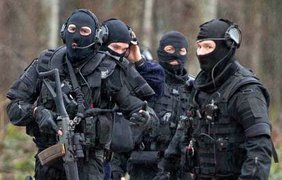 Вооружённые сотрудники сил безопасности прочёсывают лес в поисках террористов, причастных к расстрелу редакции сатирического журнала Charlie Hebdo в Париже