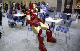 Мужчина в костюме Железного человека сидит в кафе на ежегодном съезде поклонников поп-культуры London Super ComicCon в Лондоне