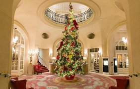Новогодняя ёлка, украшенная красными и золотыми бантами, высотой почти в два этажа в гостинице The Ritz в Лондоне