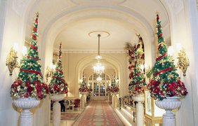 Коридоры гостиницы The Ritz в Лондоне украшены небольшими ёлками, обвитыми красными лентами и гирляндами