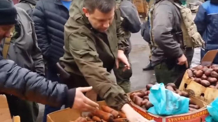 Захарченко взвешивает пистолет на рынке