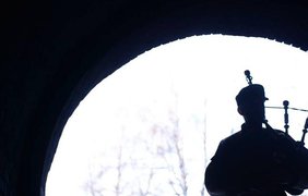 Музыкант играет на волынке в зимнем лесу