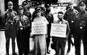 1935. Солдаты СС вместе с нарушителями закона о расовой чистоте. На шее задержанной женщины плакат с надписью "Я большая свинья и я даю только евреям!"
