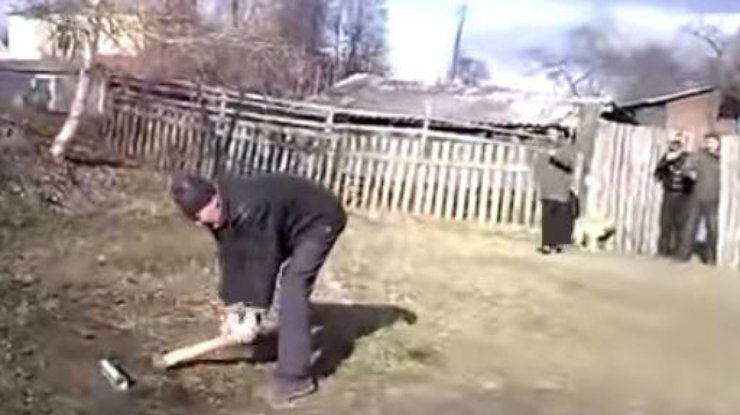 В России мужик пытался попасть топором по банке с пивом. Кадр из видео 