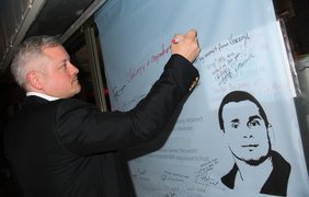 Игорь Янковский подписывает плакат с требованем освободить кинорежиссера Олега Сенцова.
