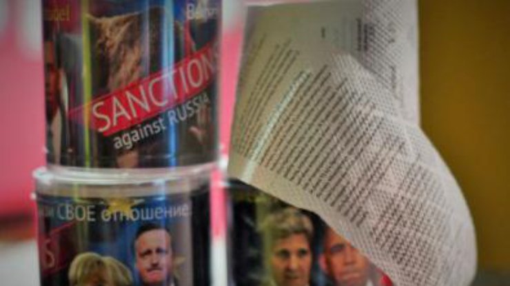 Бумага с текстом санкций упакована в тубу с фото Меркель, Обамы и Кэмерона. Фото FlashSiberia