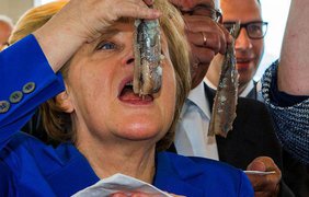 Фрау Меркель ест рыбу