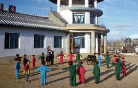 Северная Корея. Дети танцуют под аккомпанемент учителя