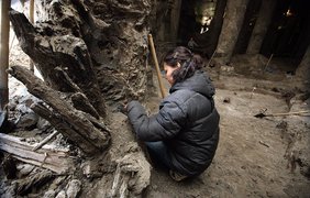 Археологи аккуратно очищают найденные деревянные артефакты от грязи
