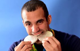 Еще один олимпиец проверяет на прочность медаль 