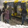 Снігопад у Києві: пасажири на зупинках перестрибують через півметрові кучугури