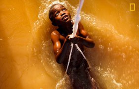 "Борьба с волной" - мальчик с веревкой играет в реке Нигер, сражаясь с приливом