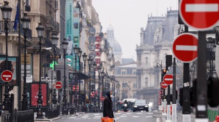 Мужчина в защитной маске пересекает пустынную улицу Риволи в Париже, 18 марта 2020 года/REUTERS