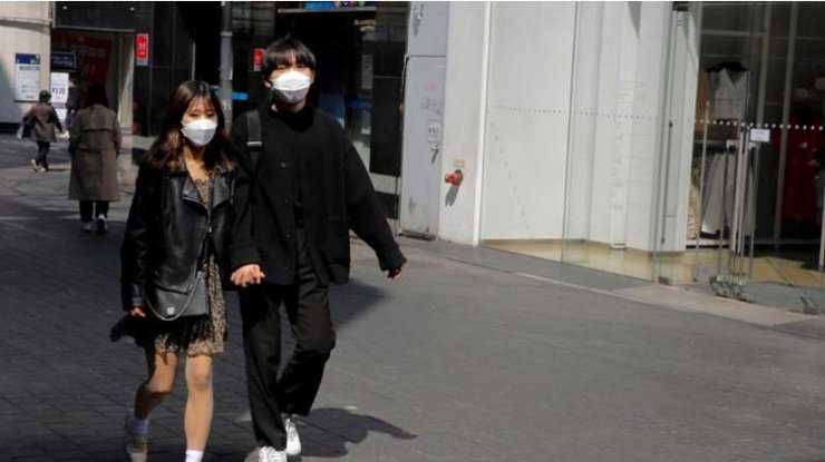 На улицах Сеула практически невозможно встретить людей без защитных масок, Южная Корея, 23 марта 2020 года/REUTERS