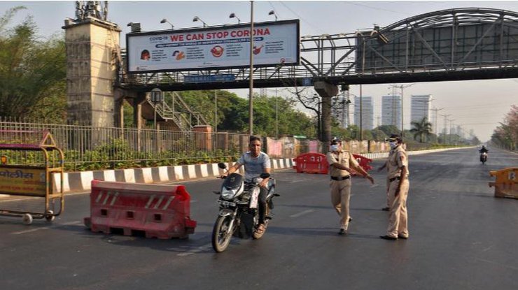 Полицейские на блок-посту в Мумбаи путаются остановить мотоциклиста, 24 марта 2020 года/REUTERS