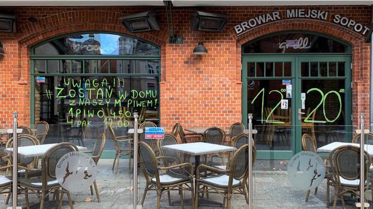 Надпись на витрине закрытого ресторана в польском Сопоте: "Внимание! Оставайтесь дома с нашим пивом"/REUTERS