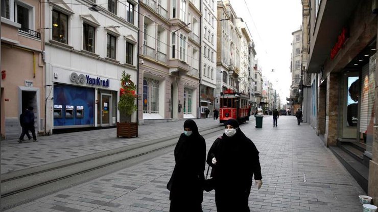 Женщины в защитных масках и перчатках в Стамбуле, Турция, 26 марта 2020 года/REUTERS