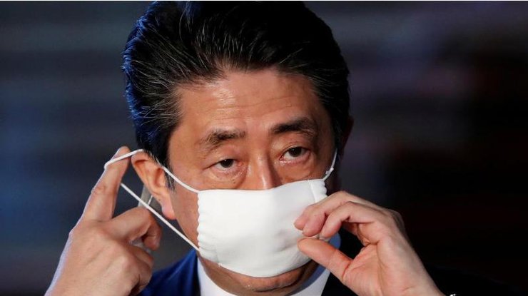 Премьер-министр Японии Синдзо Абэ поправляет маску во время выступления перед СМИ о вспышке коронавируса в Токио, 6 апреля 2020 года/REUTERS