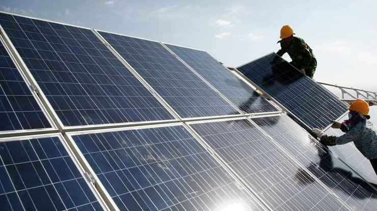 Робітники встановлюють сонячні батареї