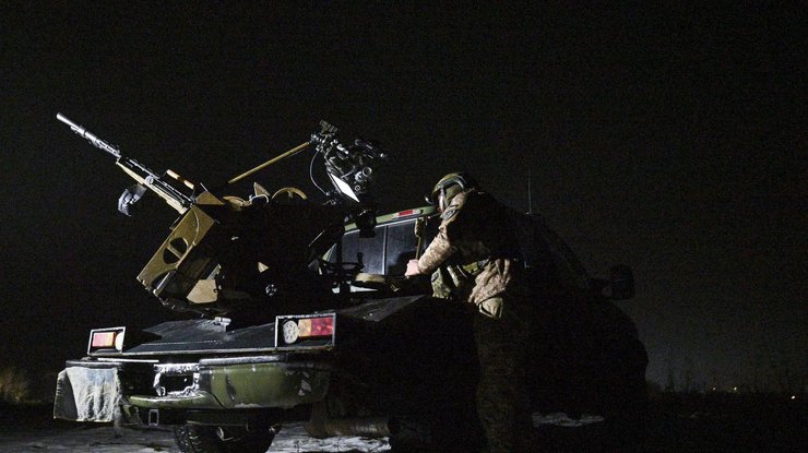 Український військовослужбовець мобільного загону ППО стоїть біля пікапа з кулеметом під час нічного патрулювання в Чернігівській області, Україна, 2 грудня 2024 року