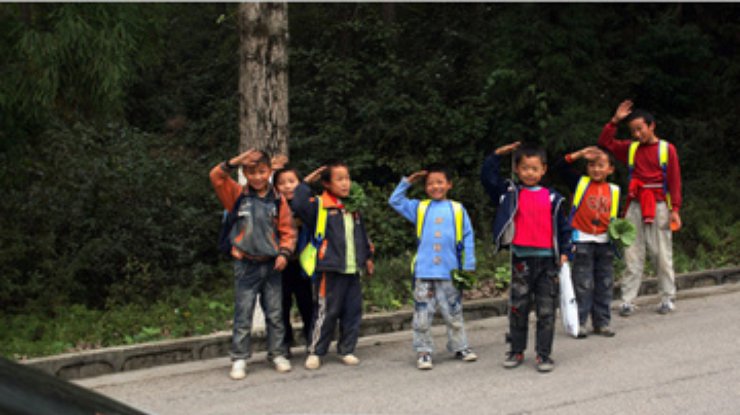 Китайских детей заставляют приветствовать проезжающие мимо машины