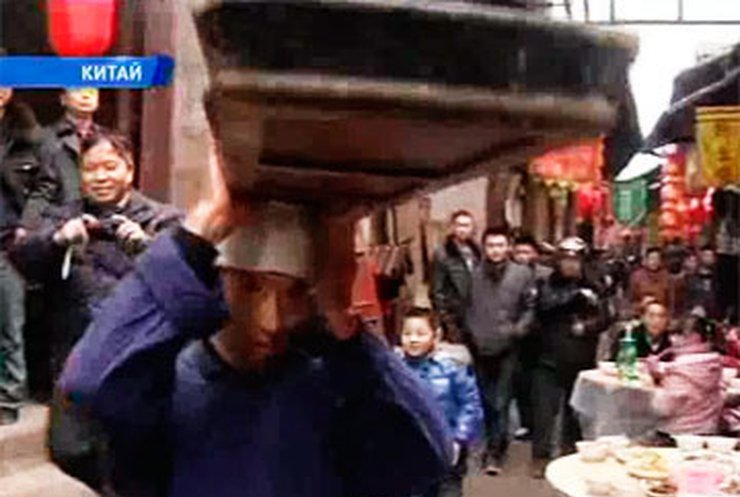 В Китае работает официант-акробат, разносящий заказы на голове