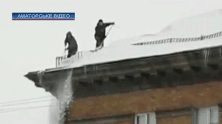 С киевских крыш сбивают снег и сосульки, не обращая внимания на прохожих