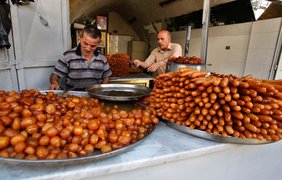 Палестинские продавцы готовят подносы сладостей для Рамадана, в магазине города Наблус