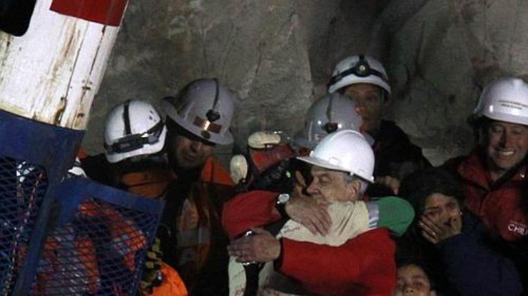 Первый спасенный шахтер обнимает президента Чили Себастьяна Пеньеру