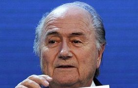Зепп Блаттер показывает карточку с надписью "Катар" - хозяевами ЧМ-2022
