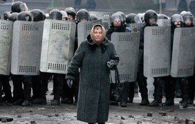 21 января, пожилая женщина на фоне кордона силовиков.
