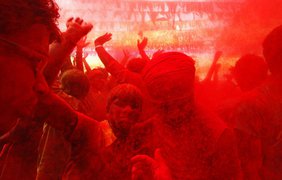 Люди танцуют во время празднования Холи в Гувахати, Индия, 17 марта 2014 года.
