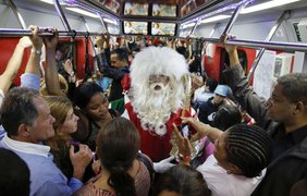 Санта Клаус едет в переполненном вагоне метро в Сан-Паулу, Бразилия, 5 декабря 2014 года.