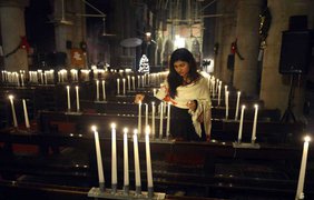 Пакистанская христианка зажигает свечи перед молитвой о душах жертв теракта в школе в Пешаваре, в Лахоре, 21 декабря 2014 года.